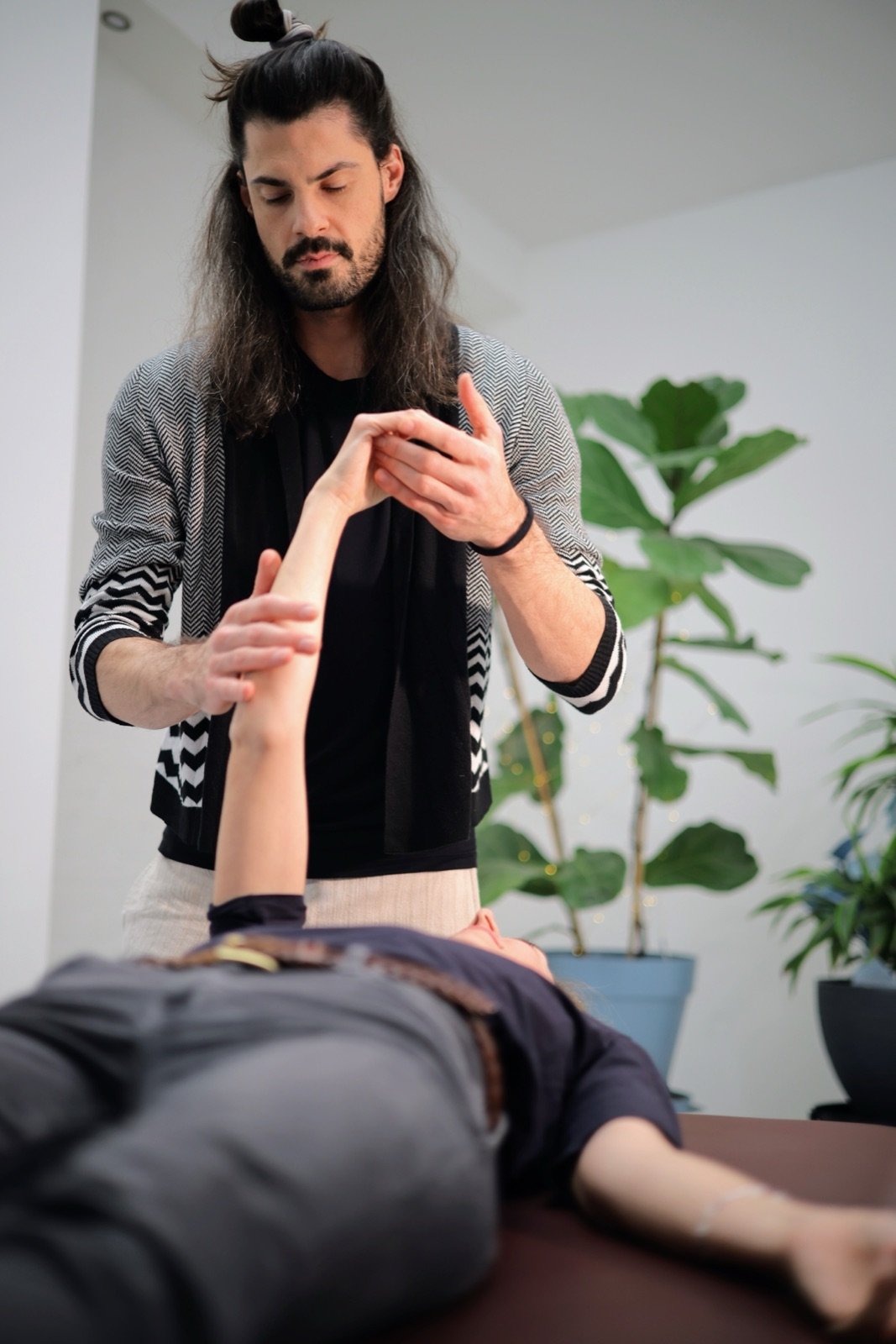 Immanuel guiding a client's raised arm through a slow movement