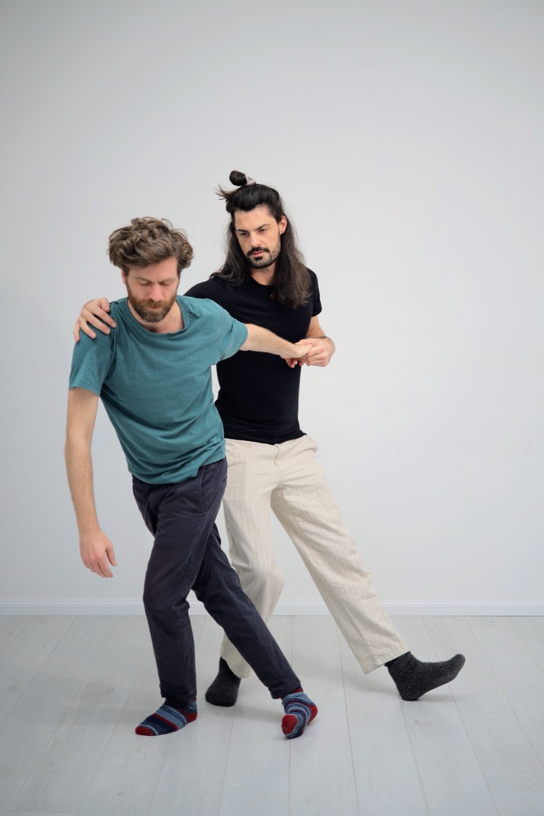 Two people in slow partnered movement, one guiding the other from behind