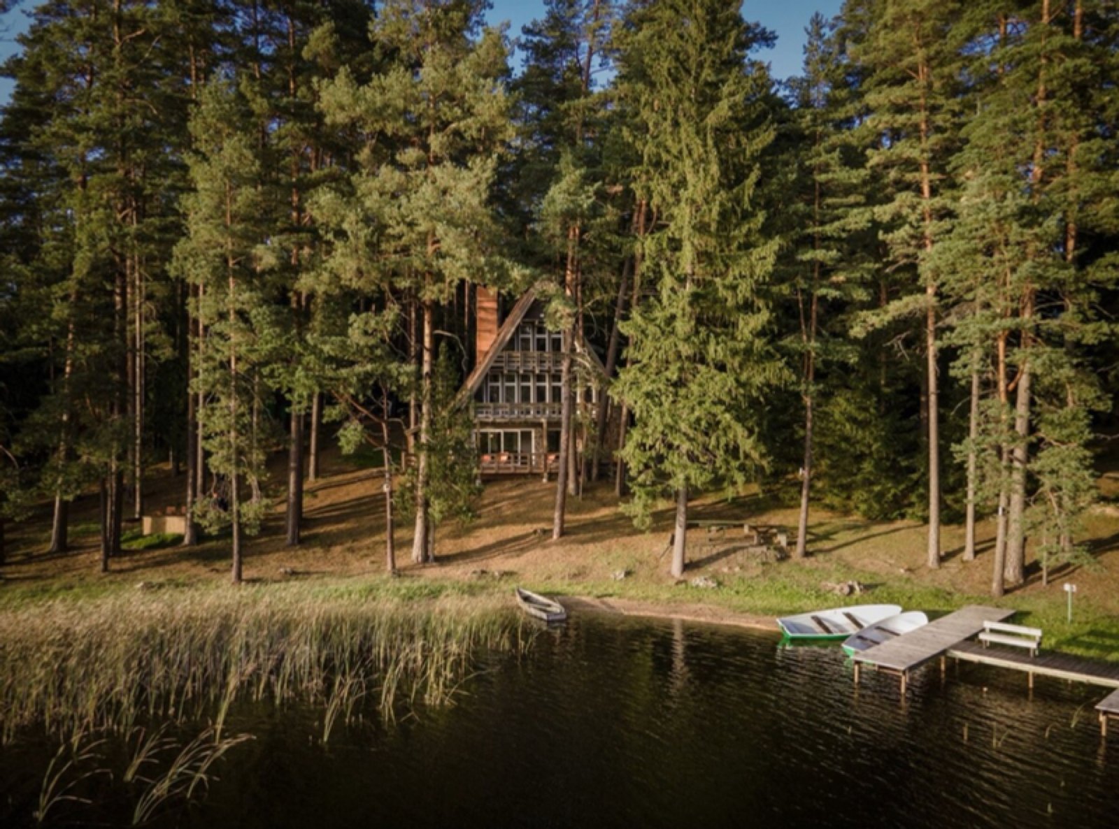 The retreat house by the lake, hidden among tall pines in Labanoras Forest